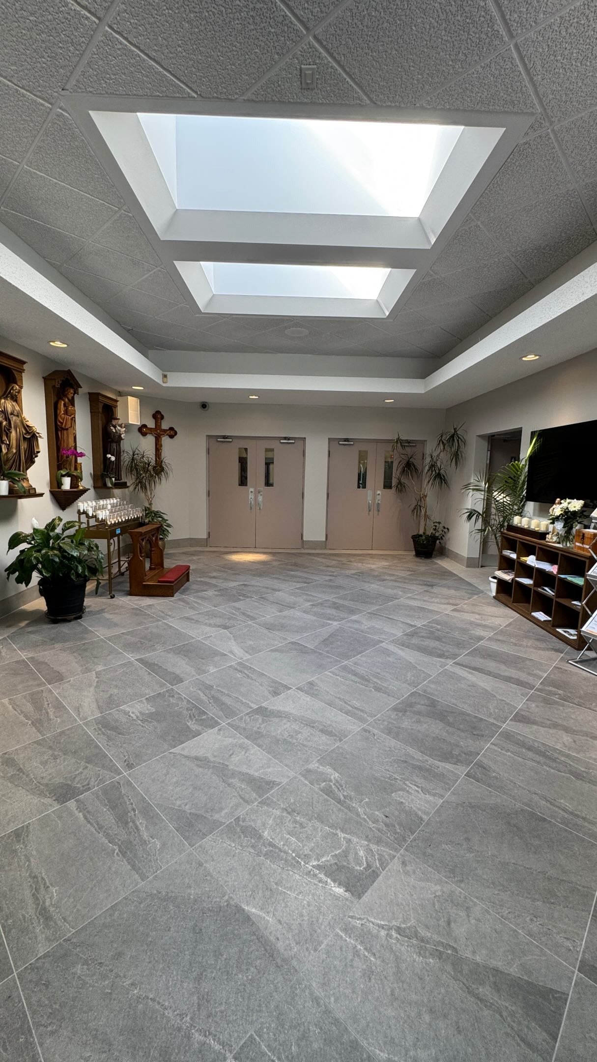 Large-format stone tile floor installation in an open hall